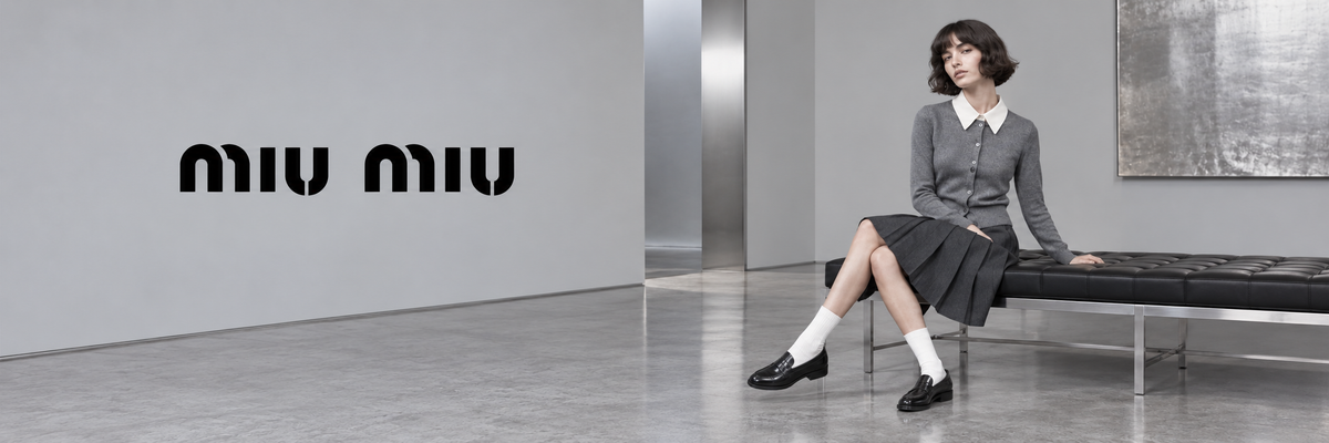 Miu Miu mode – vrouw in grijze trui en plooirok met loafers