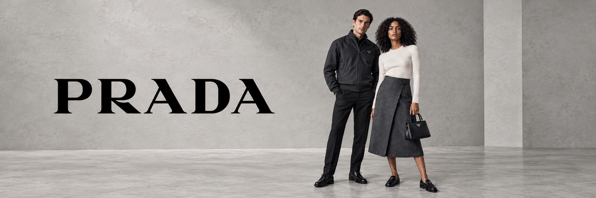 Prada designermode – man in zwarte jas en vrouw in zwarte rok met Prada tas