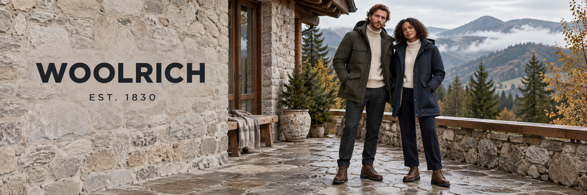 Woolrich winterjassen – man en vrouw in parka's bij een berghut